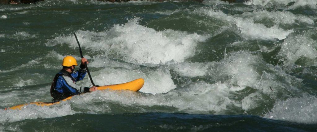 Kayaker in river rapids